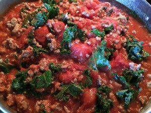 Chop up the tomatoes while stirring. 