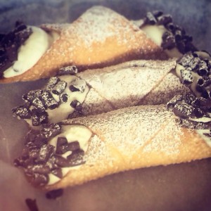 These cannoli from Colanglo's bakery in Pittsburgh's Strip District are dipped in chocolate. A typical plain cannoli is filled with ricotta cheese and dipped in crushed pistachios. Cannoli are now made with various flavors and toppings.